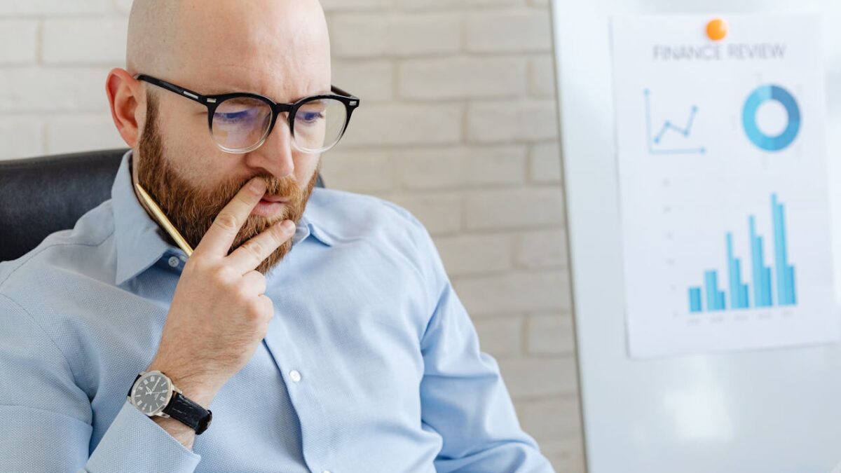 Financial professional reviewing business performance charts and financial reports during a financial planning session
